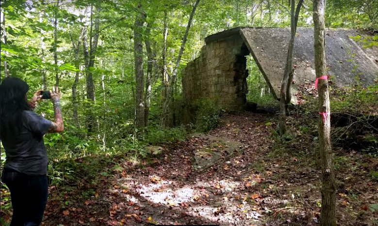 A historian at Wolf Creek Park documents a stone remnant of the mining industry there.
