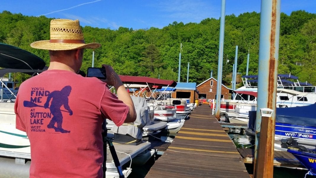 David Sibray sports a bigfoot souvenir t-shirt while photographing the Sutton Lake Marina.