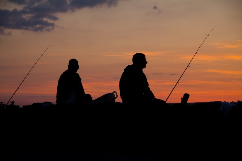 Anglers watch the sun set on a West Virginia lake.
