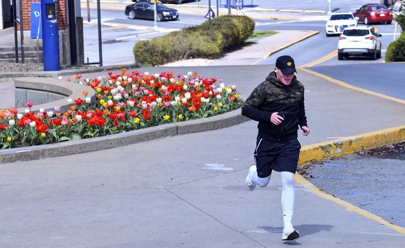 A jogger runs past the Chambers College of Business and Economics during the coronavirus outbreak.