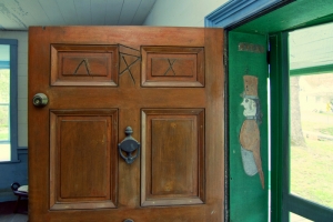 The image of a soldier appears in a threshold alongside mysterious slashes on a tavern door.