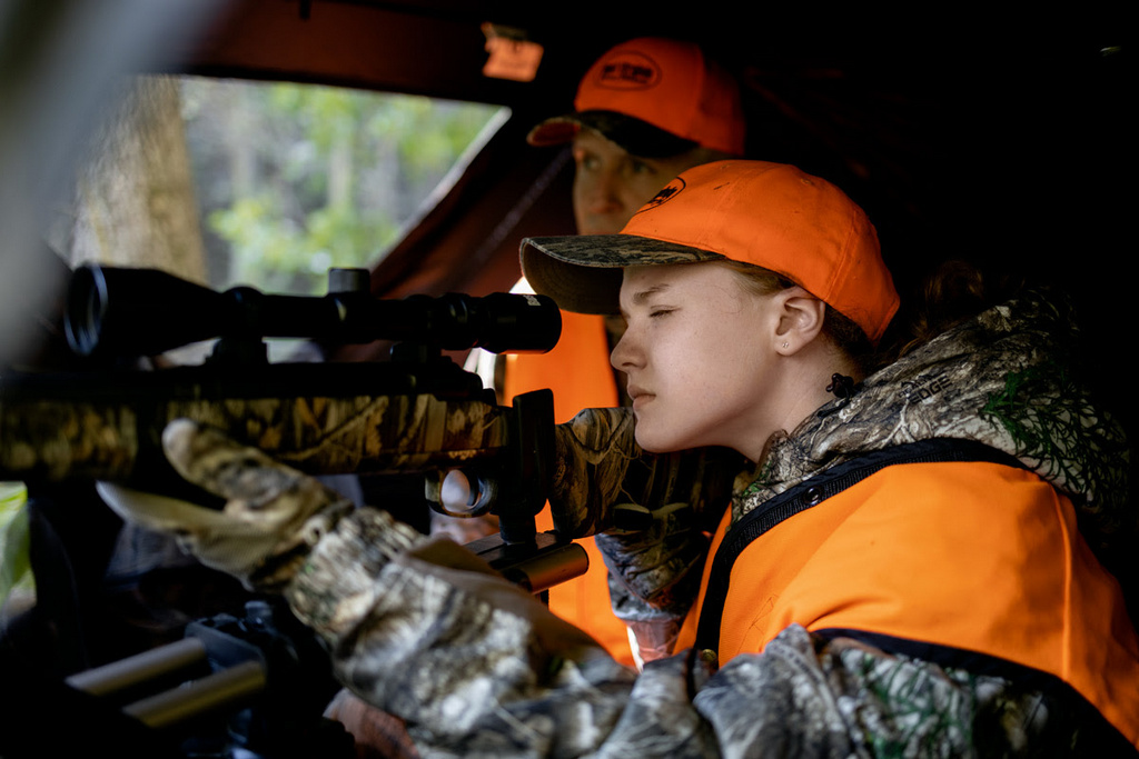 A young hunter aims from behind a blind in West Virginia.