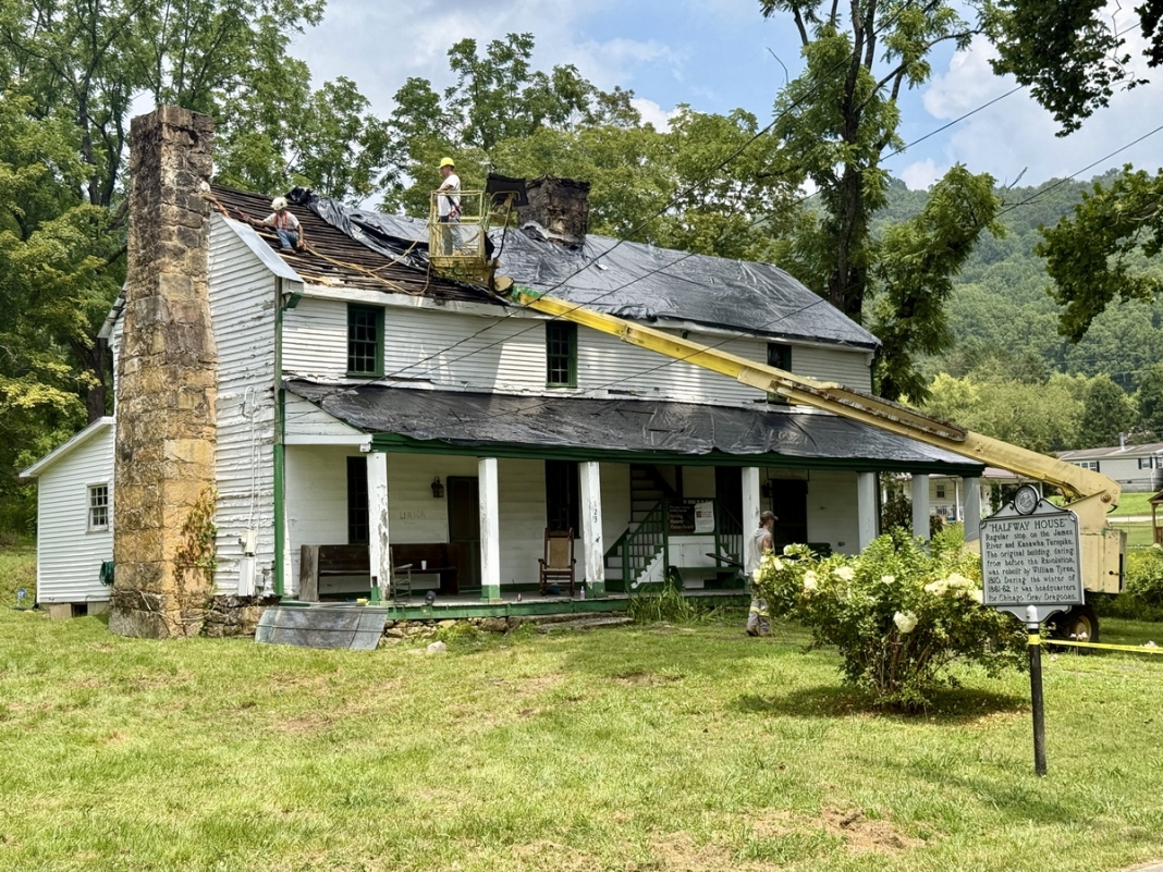 Workers prepare the Tyree Tavern for a new standing-seam metal roof.