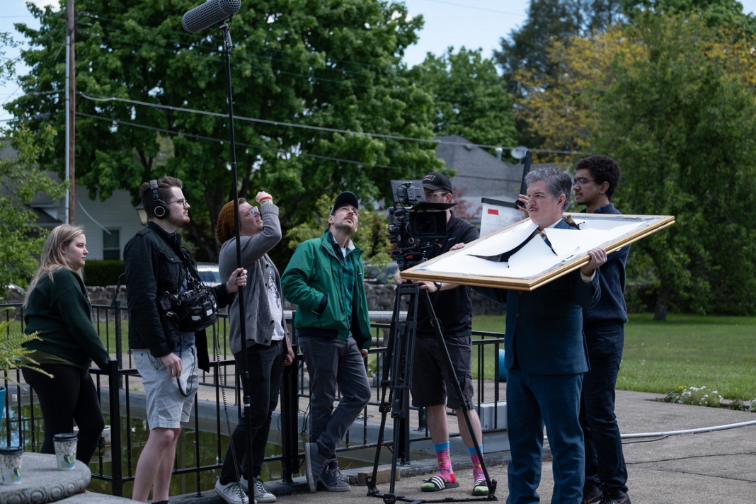 Directors gauge lighting while filming a scene from the comedy 
