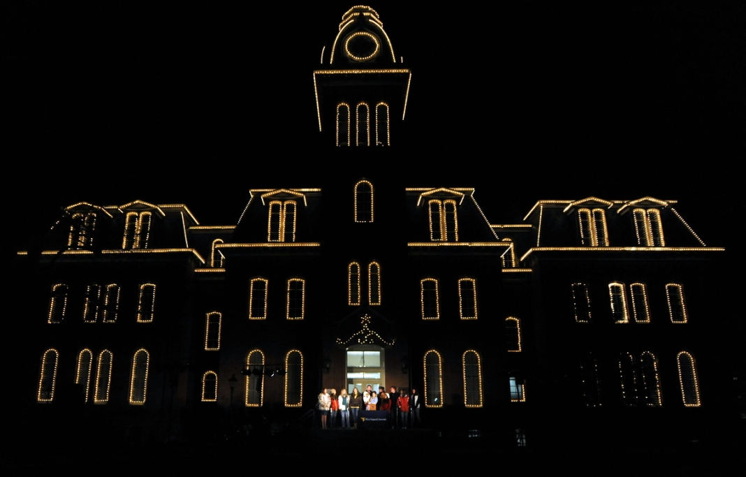 Woodburn Hall History: Holiday carolers sing outside the entrance to Woodburn Hall.